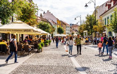Sibiu, Romanya - 2019. İnsanlar ve turistler öğle yemeği ve değnek yiyor