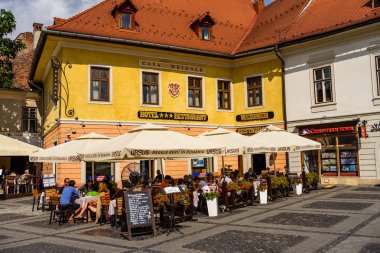 Sibiu, Romanya - 2019. İnsanlar ve turistler öğle yemeği ve değnek yiyor
