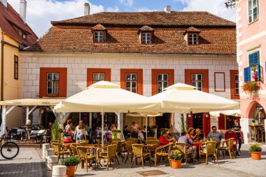 Sibiu, Romanya - 2019. İnsanlar ve turistler öğle yemeği ve değnek yiyor