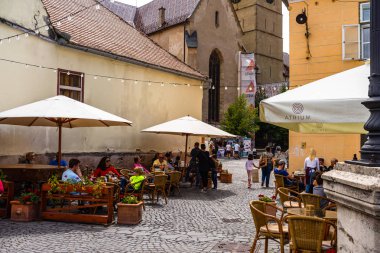Sibiu, Romanya - 2019. İnsanlar ve turistler öğle yemeği ve değnek yiyor