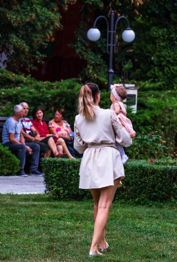 Parkta yürüyen genç anne kızını kucağına aldı.