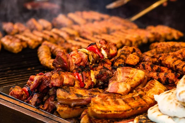 Saftig dampfendes Fleisch auf einem Holzkohlegrill, Schweinesteaks, Hühnerbrust — Stockfoto