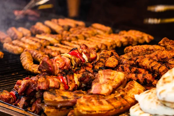 Saftig dampfendes Fleisch auf einem Holzkohlegrill, Schweinesteaks, Hühnerbrust — Stockfoto