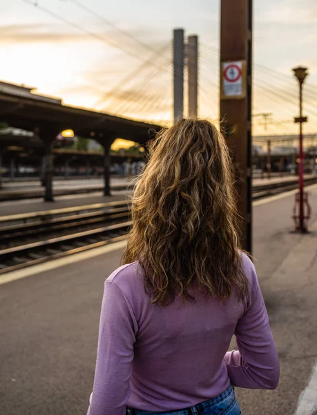Девушка, идущая одна по железнодорожной платформе и фотографирующая — стоковое фото