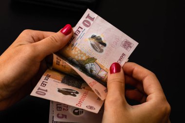 Kadın para sayıyor, Lei'yi yakın sayarak.
