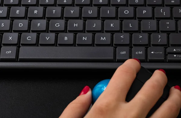 Female hand using pc mouse and keyboard. Close up woman hand on