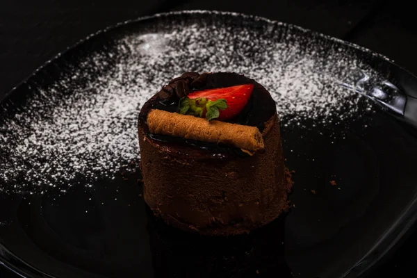 巧克力慕斯与草莓和巧克力棒在黑色 — 图库照片