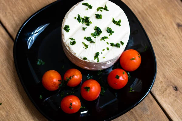 Breakfast food, cheese and cherry tomatoes on dish, on a rustic — Stock Photo, Image