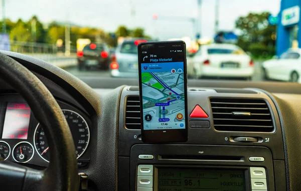In car dashboard view with smartphone showing Waze maps to show — Stock Photo, Image
