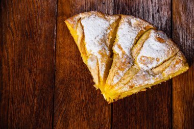 Tahtaya şeker tozu sürülmüş taze pişmiş elmalı turta. Hom