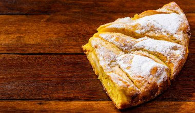 Tahtaya şeker tozu sürülmüş taze pişmiş elmalı turta. Hom