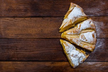 Tahtaya şeker tozu sürülmüş taze pişmiş elmalı turta. Hom