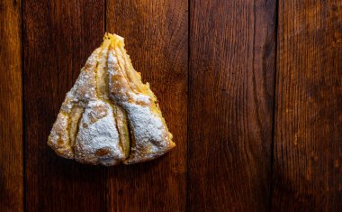 Tahtaya şeker tozu sürülmüş taze pişmiş elmalı turta. Hom