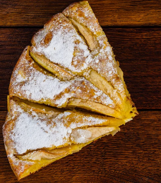 Freshly baked apple pie with sugar powder on a wooden board. Hom — Stock Photo, Image