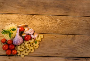 Tahtada kiraz domatesleri, sarımsak ve makarna. Yiyecek konsepti.