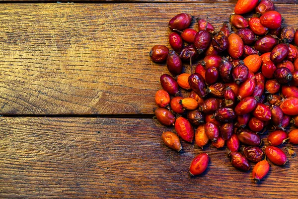 Mucchio di rosa canina secca su una tavola di legno . — Foto Stock