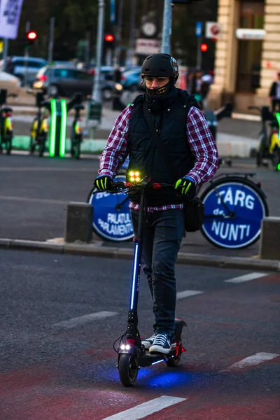 Młody człowiek na skuterze elektrycznym na ulicy w Bukareszcie, Rzym — Zdjęcie stockowe