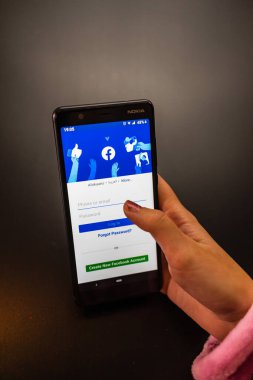 Sosyal İnternet hizmetleri Faceboo 'su olan Nokia telefonu tutan kadın.