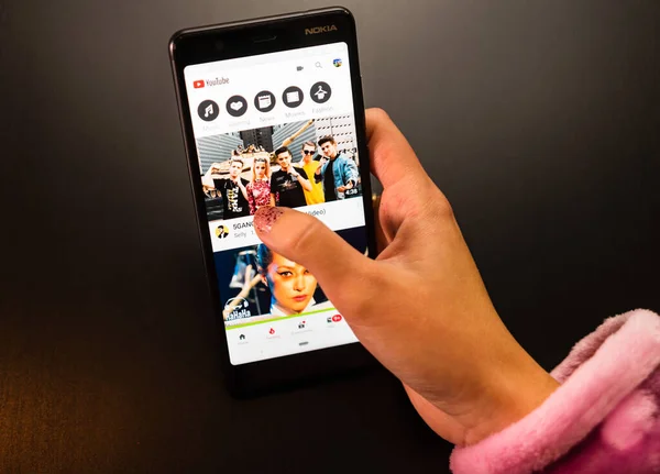 Женщина держит телефон Nokia с социальным интернет-сервисом YouTube — стоковое фото