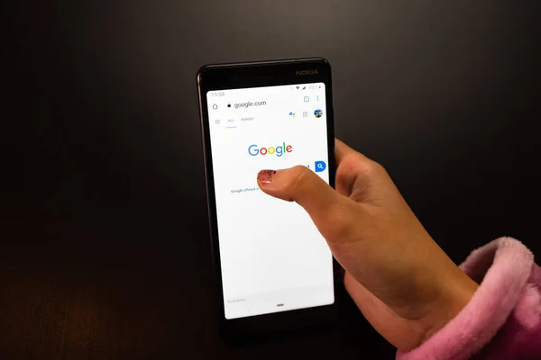 Frau hält ein Nokia-Telefon mit google Internet-Service auf der — Stockfoto