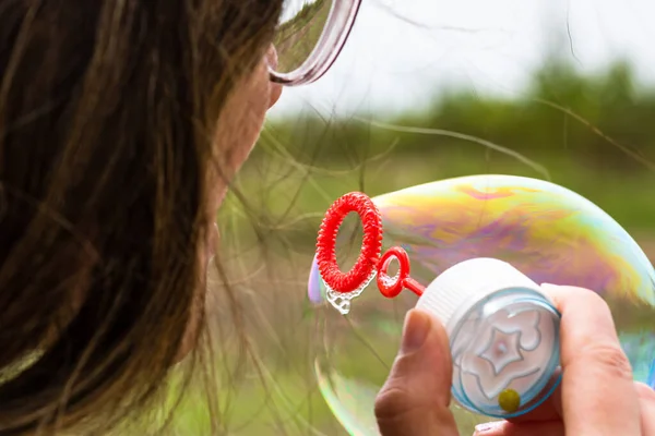 stock image Close up photo of a girl blowing soap bubbles outdoor.