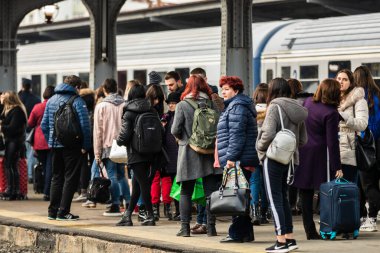 Bükreş 'teki Bükreş Kuzey Tren İstasyonu' nun (Gara de Nord Bükreş) tren peronunda tren bekleyen gezginler ve banliyö sakinleri, 2020