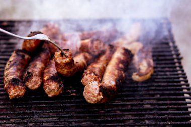 Kömür mangalında ızgara sosis. Lezzetli barbekü, yemek konsepti, ızgaradaki yemek ve ızgaradaki sosislerin ayrıntıları.