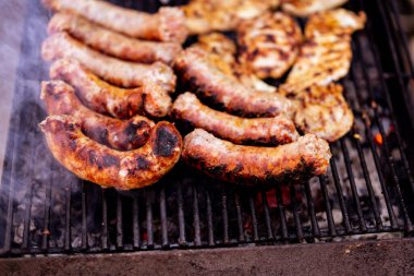 Kömür mangalında ızgara domuz eti ve sosis hazırlıyorum. Lezzetli barbekü, yemek konsepti, ızgaradaki yemek ve ızgaradaki yemeğin ayrıntıları.