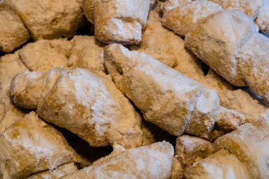Kısa hamurlu hamur işi kruvasan rulosu, Romanyalı pudra şekerli kornulet izole edilmiş yakın çekim