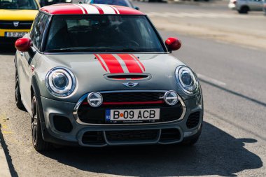 Kırmızılı gri renkli araba Mini Cooper, Romanya 'nın Eski Bükreş kentindeki caddeye park etti.