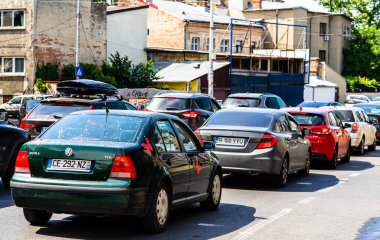 Trafik sıkışıkken kırmızı ışıkta durdu. Romanya 'nın başkenti Bükreş' te sabah ve akşam araba kirliliği, trafik sıkışıklığı
