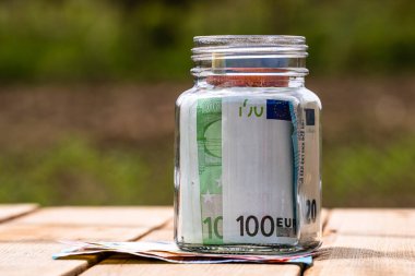 Cam bir kavanozda para biriktirme kompozisyonu. Yatırım yapma ve para tutma kavramı, tecrit edilmiş..