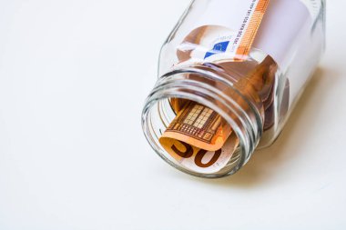 Cam bir kavanozda para biriktirme kompozisyonu. Yatırım yapma ve para tutma kavramı, tecrit edilmiş..