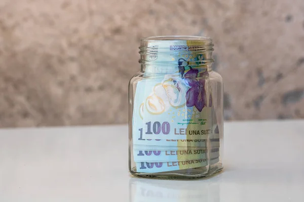 Tasarruf edilen kompozisyon. Romanyalı LEI banknotları cam bir kavanozda. Yatırım yapma ve para tutma kavramı, tecrit edilmiş..
