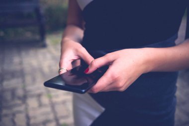 Kadın elleri dışarıda akıllı telefon kullanıyor..