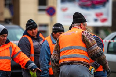 Yansıtıcı yelek giyen müteahhit işçiler sokak kaldırımlarını onarmaya hazırlanıyorlar. Bükreş, Romanya, 2020
