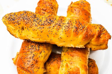 Hamurun içine tuz ve haşhaş tohumu serpiştirilmiş sosisleri kapatın. Sosisli börek, nefis ev yapımı börekler..