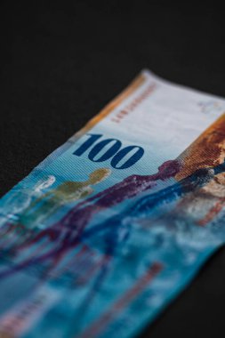 100 İsviçre frangı banknotunun detaylarına özen göster. Para banknotlarının makro detaylarını kapat, İsviçre frangı izole edilmiş. Dünya para kavramı, enflasyon ve ekonomi kavramı