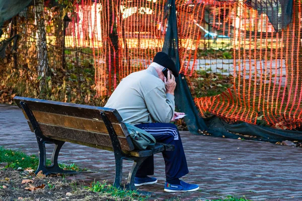 Visszapillantás Egy Öregemberre Aki Padon Áll Parkban Miközben Telefonján Beszél — Stock Fotó