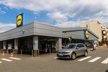 Alışveriş yaparken, LIDL süpermarketinin girişinde, Romanya 'nın Bükreş kentinde otoparklı cerrahi maske takanlar.