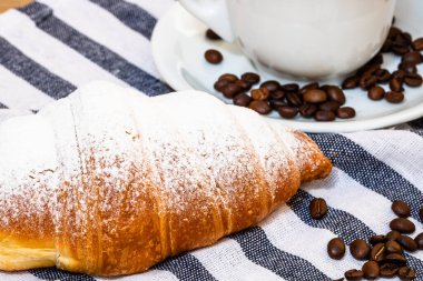 Puf böreği, kahve fincanı ve ahşap sandıkta tereyağlı Fransız kruvasanı. Yemek ve kahvaltı konsepti. Kahve tatlısı ve taze hamur işlerinin detayları.