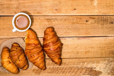Tahta masada taze kruvasan ve bisküvi. Kahve, yemek ve kahvaltı konsepti. Tatlılar, taze hamur işleri ve kahve. Üst görünüm ve kopyalama alanı