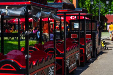 Parkta turistler için tren yolculuğu. 2020 yılında Romanya 'nın Bükreş kentindeki Mogosoaia kentinden insanlar park ve bahçelerde yürüyor, dinleniyor ve eğleniyorlar..