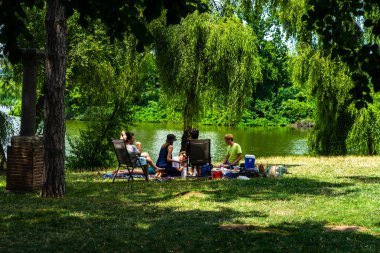 İnsanlar 2020 yılında Romanya 'nın Bükreş kentindeki Mogosoaia bölgesinden parktaki Coronavirus krizi sırasında piknik yapıyor ve eğleniyorlar..