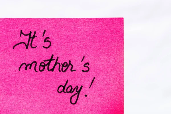 It is mother day handwriting text close up isolated on pink paper with copy space. Writing text on memo post reminder