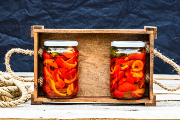 赤ピーマンを漬けガラス瓶で木製のクレート 保存食のコンセプト 素朴な組成で隔離された缶詰の野菜 — ストック写真