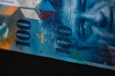 100 İsviçre frangı banknotunun detaylarına özen göster. Para banknotlarının makro detaylarını kapat, İsviçre frangı izole edilmiş. Dünya para kavramı, enflasyon ve ekonomi kavramı