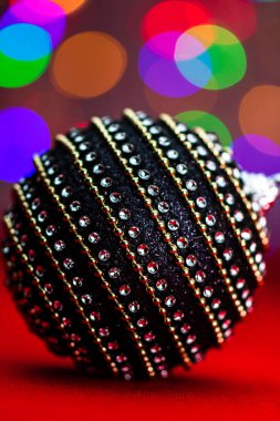 Siyah ve parlak bir Noel balosu. Bulanık ışıkların arka planında bir Noel kompozisyonu..