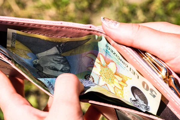 Romen parasıyla el ele tutuşup cüzdanı gösteriyor LEI.