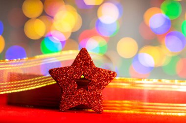 Renkli bir Noel kompozisyonu olan kırmızı parıltılı süslemeler bulanık ışıkların arka planında izole edilmiş..